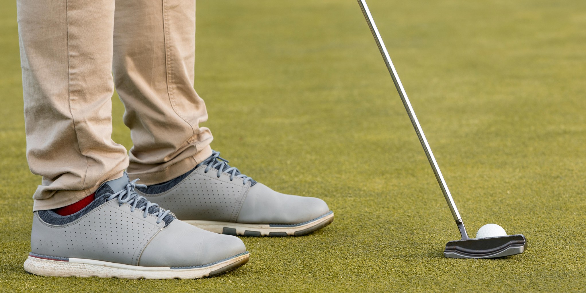 Golf shoes and a putter on the green - GemTees